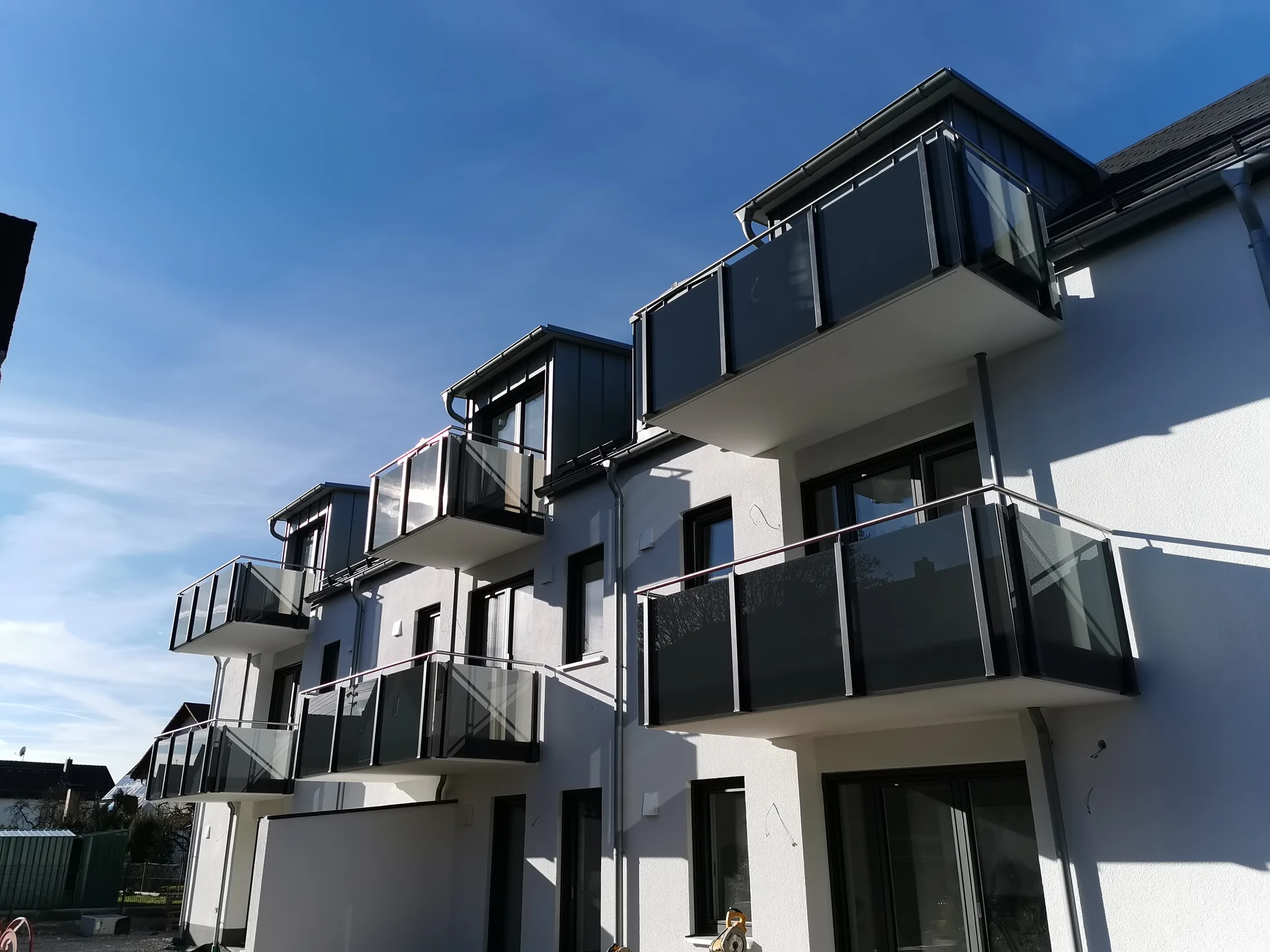 Balkongeländer Anlage Glas in grau und Scheiben bis Unterkante Balkon – Geländer Referenz